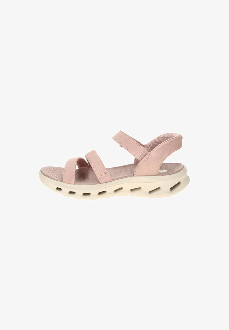 Sandale rose clair à bout ouvert avec des brides réglables et une semelle blanche épaisse avec des découpes de ventilation.