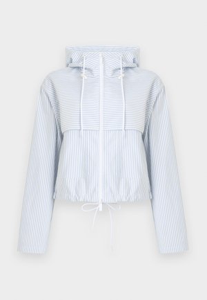 Korte capuchonjas gemaakt van lichtblauwe stof met witte strepen, voorzien van een ritssluiting aan de voorkant, verstelbare trekkoorden en twee zijzakken.