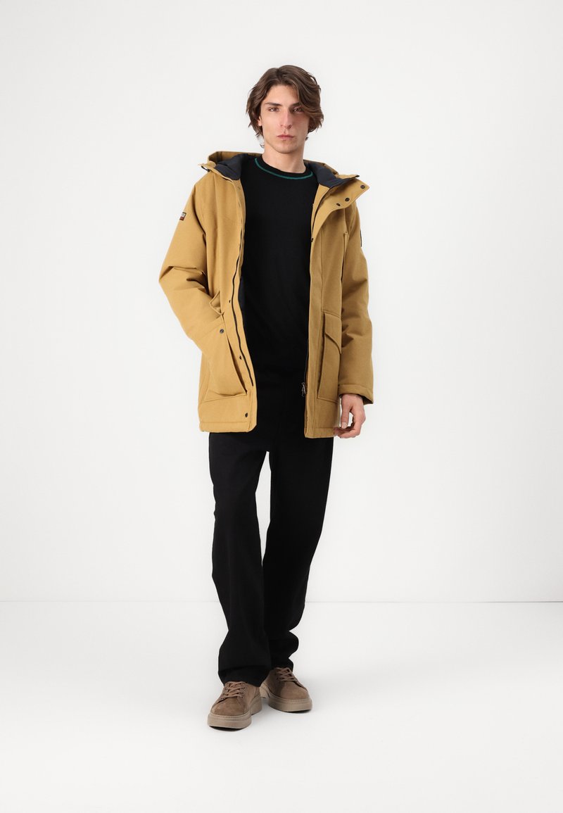 Chaqueta de invierno amarilla con capucha y un forro interior negro, que presenta una cremallera frontal, cierres a presión y dos grandes bolsillos laterales.