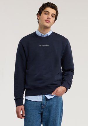 Marineblauer Sweatshirt aus Baumwollmischung mit Rundhalsausschnitt und gerippten Bündchen. Logo "TRUSSARDI 1911" auf der Brust gedruckt.