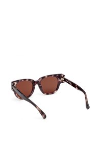 Cat-eye sunglasses with a tortoise shell pattern, brown tinted lenses, and subtle gold hardware accents on the arms. Textured finish.