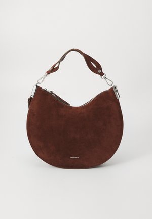 Brown suede hobo bag with a curved silhouette, silver hardware, and a zipper closure. Features a short, adjustable strap.