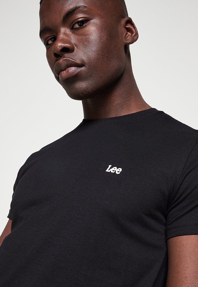 Czarny bawełniany t-shirt z okrągłym dekoltem i krótkimi rękawami, z małym białym logo "Lee" po lewej stronie klatki piersiowej.
