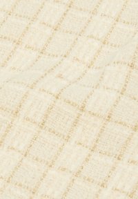 Tessuto intrecciato di un crema chiaro con motivo a reticolo e fili metallici dorati, che mette in mostra una superficie testurizzata e una lucentezza sottile.