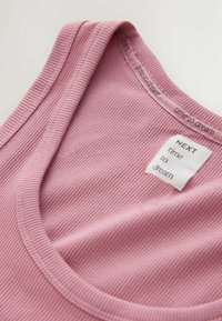 Maieu roz cu dungi și decolteu rotund. Eticheta spune „NEXT time to dream.” Textură fină cu o senzație ușor elastică.