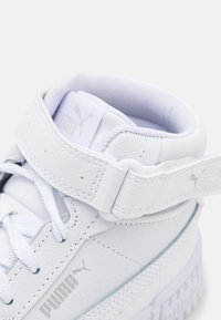 Witte leren sneakers met een gevoerde kraag, geperforeerde accenten en een klittenbandsluiting. Voorzien van een reliëflogo en een getextureerde rubberen zool.