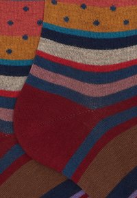 Calzini multicolori con strisce orizzontali in tonalità di bordeaux, blu e beige, con motivi a pois gialli e arancioni. Morbido tessuto lavorato a maglia.