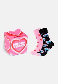 Darčeková súprava Happy Socks na Valentína obsahujúca dva páry ponožiek po lýtka: jedny ružové s červenými srdiečkami, druhé čierne s farebnými vzormi srdiečok.