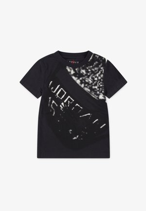 T-shirt in cotone nero con una grande stampa grafica a contrasto con il testo "JORDAN" e un logo Jumpman in tonalità di bianco e grigio. Maniche corte.