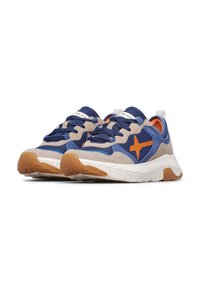 Baskets bleu et beige avec logo étoile orange, lacets navy, semelle épaisse blanche et semelle extérieure couleur gomme, vue de côté en angle sur fond blanc.