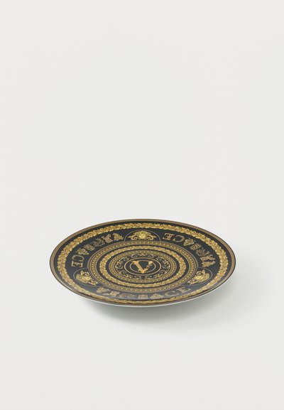 Μαύρο πιάτο με χρυσά περίτεχνα μοτίβα σε ελληνικό στυλ, κεφάλια Μέδουσας και επιγραφή «Versace» σε κυκλικό σχέδιο.