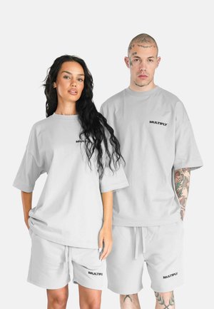 Light gray oversized t-shirts and matching shorts with "MULTIPLY" logo in black. Made from soft fabric, featuring relaxed fit and short sleeves.