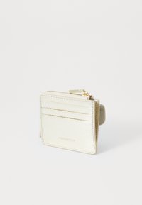 Porte-cartes en métal doré avec une finition texturée, offrant quatre emplacements pour cartes et un compartiment zippé, de forme rectangulaire compacte.
