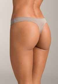 Svetlo siv tangice, brezšivna zasnova, narejene iz mehkega, raztegljivega materiala. Pas nizkega stranskega položaja in minimalno zadnje pokritje. Gladek tekstura.