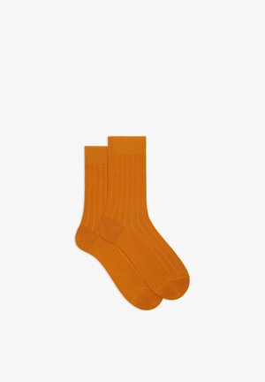 Calzini arancioni a coste con una texture liscia, caratterizzati da un design classico a metà polpaccio e da un morbido polsino a contrasto in cima.