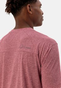 T-shirt rossa a maniche corte, in tessuto testurizzato, con un logo sulla parte posteriore vicino al collo, collo rotondo e vestibilità comoda.