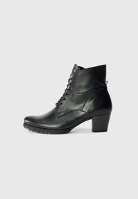 Bottine en cuir noir avec un bout rond, un système de laçage et un talon épais ; présente une texture lisse et des détails de couture subtils.