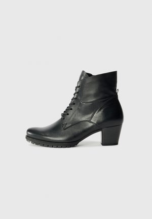 Bottine en cuir noir avec un bout rond, un système de laçage et un talon épais ; présente une texture lisse et des détails de couture subtils.