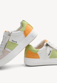 Baskets multicolores avec une base en cuir texturé blanc, des accents en daim vert et orange, une fermeture éclair sur le côté et une semelle en caoutchouc blanche.