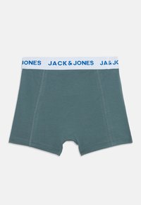 Boxershorts in een gedempte teal kleur met een witte tailleband waarop blauwe tekst "JACK & JONES" staat. Inclusief zichtbare stikseldetails.