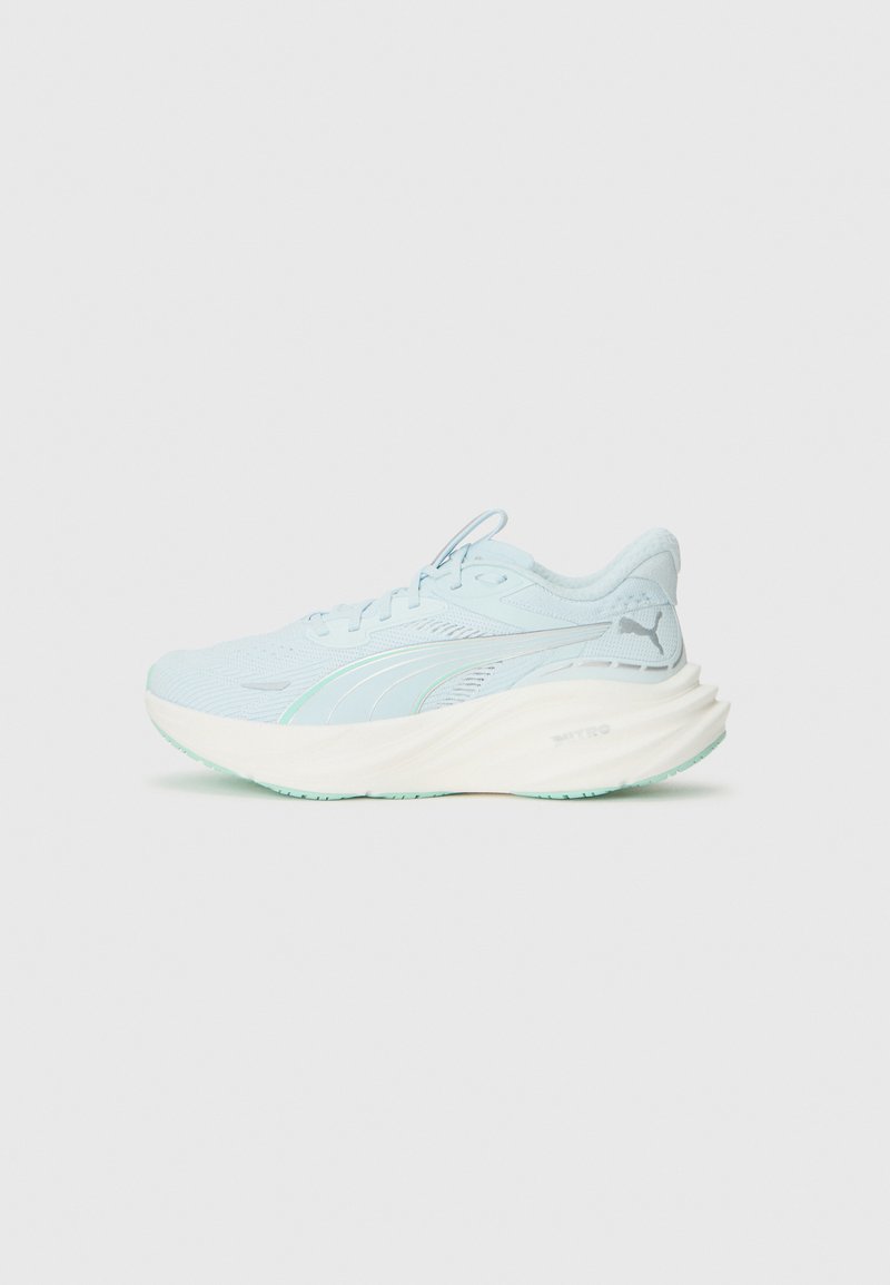 Chaussure de course Puma bleu clair avec une épaisse semelle blanche et un logo de la marque, vue de côté sur fond blanc uni.