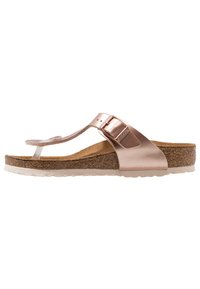 Le infradito color oro rosa presentano una parte superiore in materiale sintetico liscio, una fibbia regolabile e una soletta in sughero con una suola bianca testurizzata.