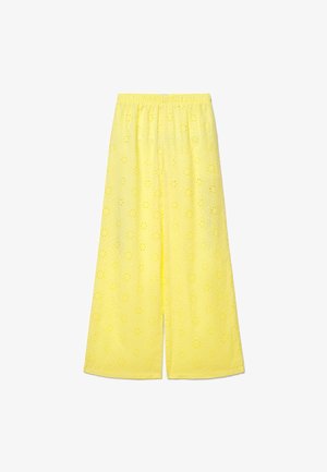 Pantalon jaune à jambe large avec une ceinture élastique et un motif floral en découpe œillets sur tout le tissu.