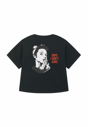 T-shirt nera oversize con una grafica di un volto con una mano sulla bocca, accompagnata dal testo "OOPS I DON’T CARE" in arancione.