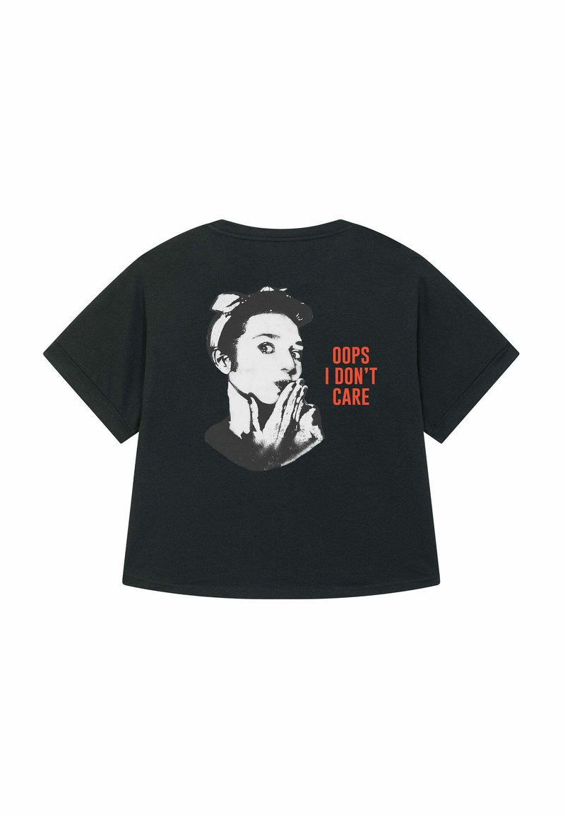 T-shirt nera oversize con una grafica di un volto con una mano sulla bocca, accompagnata dal testo "OOPS I DON’T CARE" in arancione.