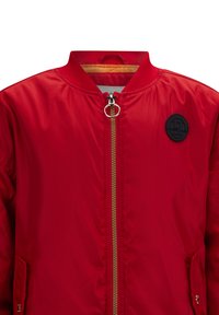 Rote Bomberjacke aus glattem Nylon mit einem gerippten Kragen, goldenem Reißverschluss, Seitentaschen und einem schwarzen runden Logopatch auf der Brust.