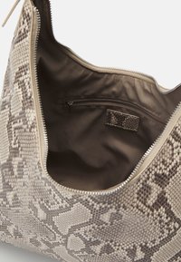 Sac hobo en imprimé serpent, tons crème et marron. Comprend une fermeture éclair, une doublure en tissu et une poche intérieure zippée pour l'organisation.