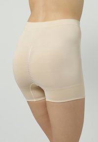 Beige shapewear shorts met een gladde textuur, middenhoog tailleband en een naadloos ontwerp, dat volledige bedekking en ondersteuning biedt.