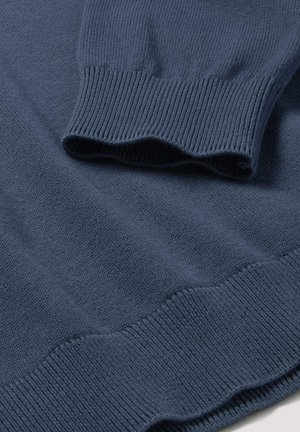 Dunkelblauer Strickpullover, mit gerippten Bündchen und Saum, glatter Textur und leicht gewelltem Rand am unteren Ende für zusätzliche Details.