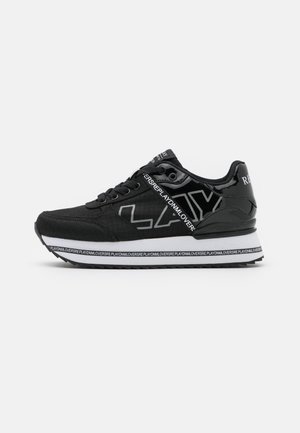 Baskets noires avec semelle blanche affichant le texte "PLAYDNMLOVERS" sur la semelle intermédiaire et le logo latéral, fermeture à lacets et détail brillant au talon.