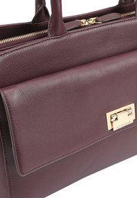 Bordeaux lederen handtas met een gestructureerde afwerking, voorzien van een goudkleurige sluiting en slanke handvatten, die een horizontaal ontwerp benadrukt.