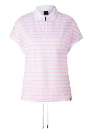 Blonde woman standing wearing a light pink striped short-sleeve top with a zip and loose white pants with drawstring and sneakers.