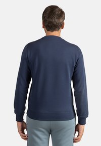 Felpa blu navy con collo a giro, polsini e bordo a costine, realizzata in un morbido tessuto misto cotone-poliestere. Design semplice e classico.
