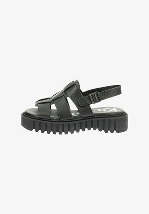 Sandales en cuir noir avec un design à plusieurs lanières, boucle ajustable et semelle en caoutchouc texturée pour une meilleure adhérence. Profil plat, style ouvert à l'avant.