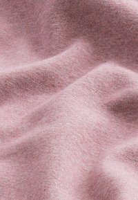Tela suave y rosa con una superficie ligeramente texturizada, que presenta un sutil patrón jaspeado. Los pliegues crean luz y sombra variadas.