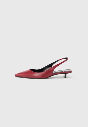 Chaussures slingback en cuir rouge avec une pointe pointue, un petit talon bloc et une texture lisse. Le design présente un talon ouvert et un style minimaliste.