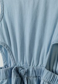 Vêtement bleu clair en tissu doux, avec une taille froncée et un détail noué. Le design comprend des épaules dénudées et une texture lisse.