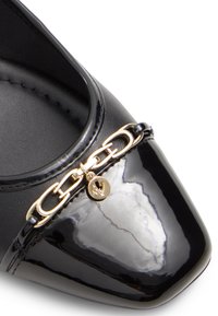 Czarne lakierowane czółenka z ostrym noskiem, złotym łańcuszkiem z serduszkiem oraz eleganckim, teksturowanym wierzchem.
