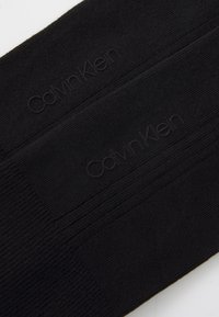 Čierne ponožky Calvin Klein s textúrovaným pleteným vzorom, s jemne embosovaným logom a klasickým dizajnom nad členkom.