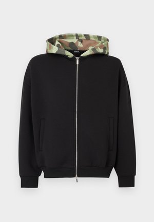 Schwarzer Kapuzenpullover mit Reißverschluss und grünem, tarnmusterfarbenem Kapuzenfutter. Verfügt über zwei Fronttaschen sowie gerippte Bündchen und Saum. Weiche Stoffstruktur.