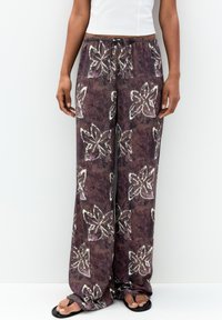 Pantaloni larghi a fantasia viola realizzati in tessuto morbido, con disegni floreali bianchi e una vita elastica con cordino.