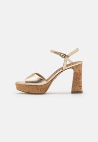 Gold metallic platform sandals with a cork block heel, open toe design, and an adjustable ankle strap for secure fit. Smooth texture.