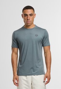 Grå kortærmet atletisk skjorte lavet af glat, fugttransporterende materiale; har et subtilt logo på brystet og en rund halsudskæring.