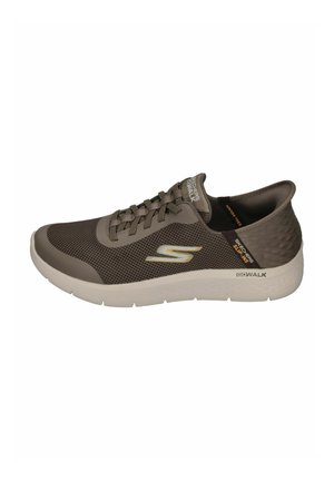 Zapatilla deportiva de malla marrón con diseño de cordones, puntera redondeada, suela blanca y talón texturizado. Logo de la marca mostrado en el costado.