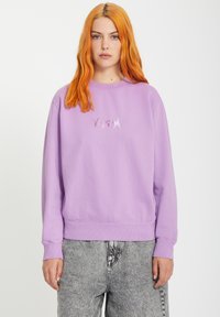 Fioletowa bawełniana bluza z okrągłym dekoltem, z prążkowanymi mankietami i dołem. Posiada wyszywany srebrny napis "VOLCOM" na piersi.