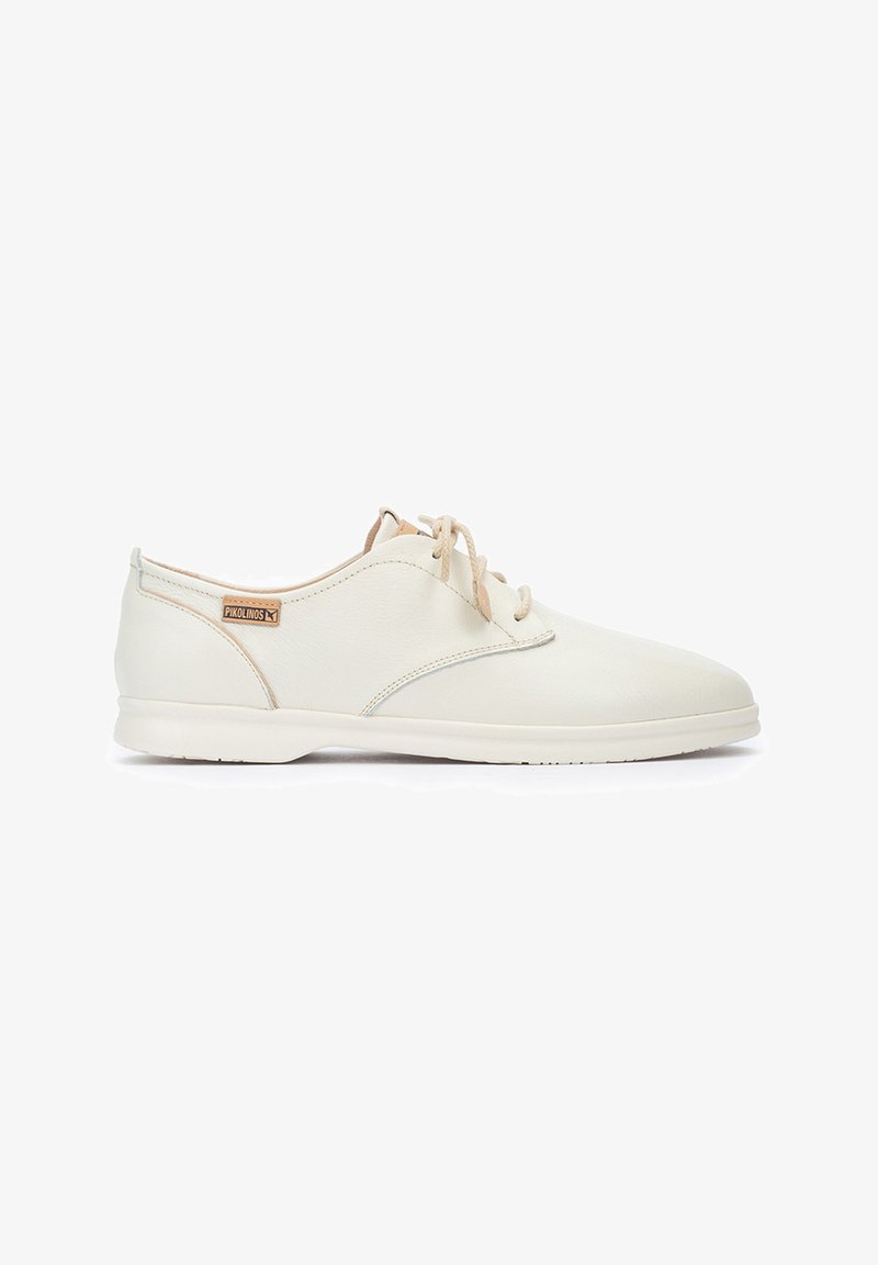 Baskets en cuir blanc à lacets avec une texture lisse, bout arrondi et détails de couture subtils. Comprend une étiquette avec la marque "Pikolinos."